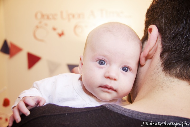 Baby looking over fathers shoulder - baby portrait photography sydney